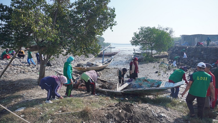 Warga LDII membersihkan sampah di pesisir Pantai Kenjeran, Minggu (6/8). Dok: LINES.